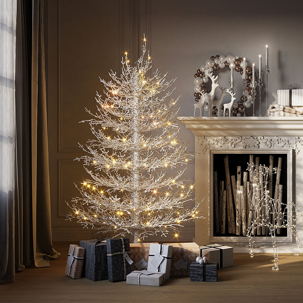 White flocked pre-lit Aspen fir tree by a fireplace, image 1 of 4