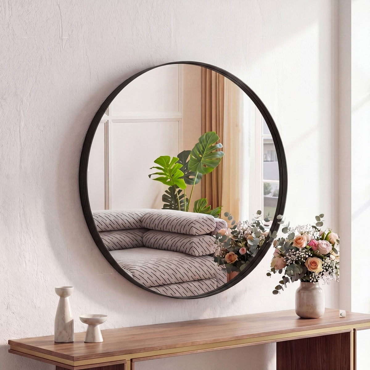Round black-framed wall mirror above a wood console, image 2 of 3