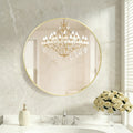 Round gold-framed wall mirror over a bathroom vanity, image 1 of 4
