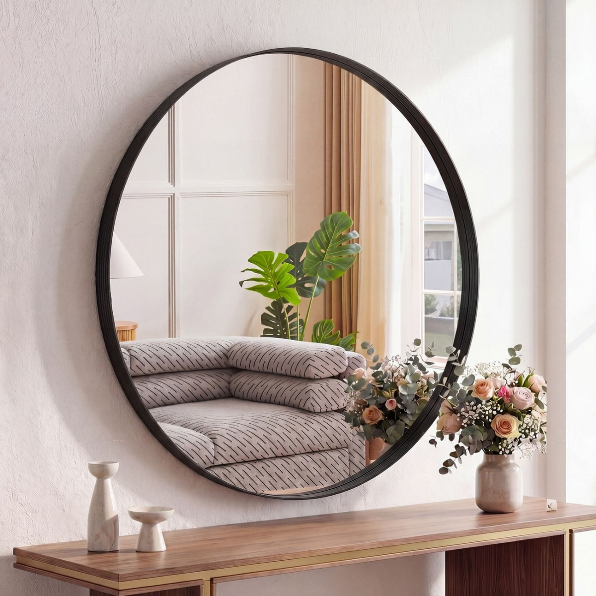 Round black-framed wall mirror above a wood console, image 1 of 3